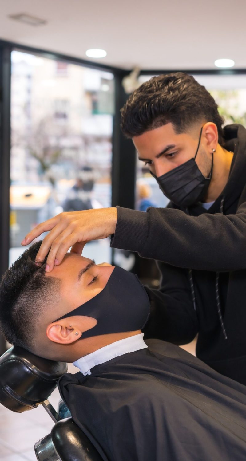 hairdresser-with-face-mask-finishing-the-cut-to-th-FSXQBGY-scaled.jpg